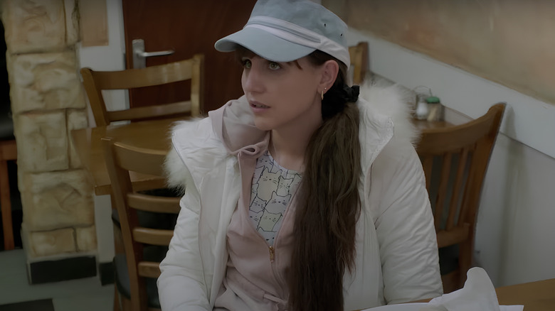 Sophie sitting at table wearing hat 