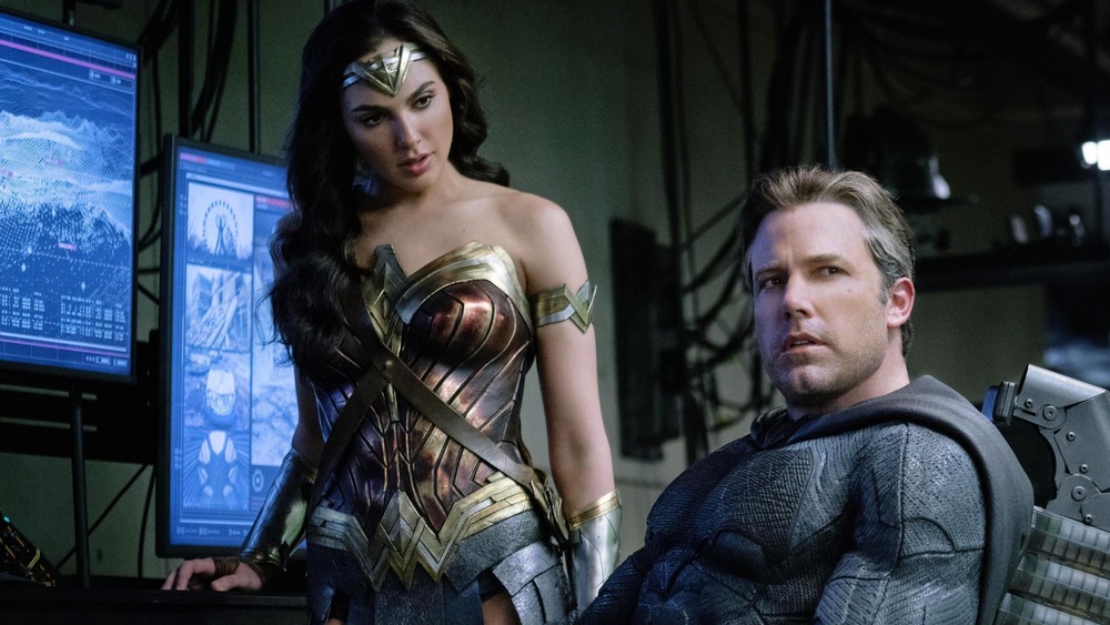 Wonder Woman standing and Batman sitting in Justice League