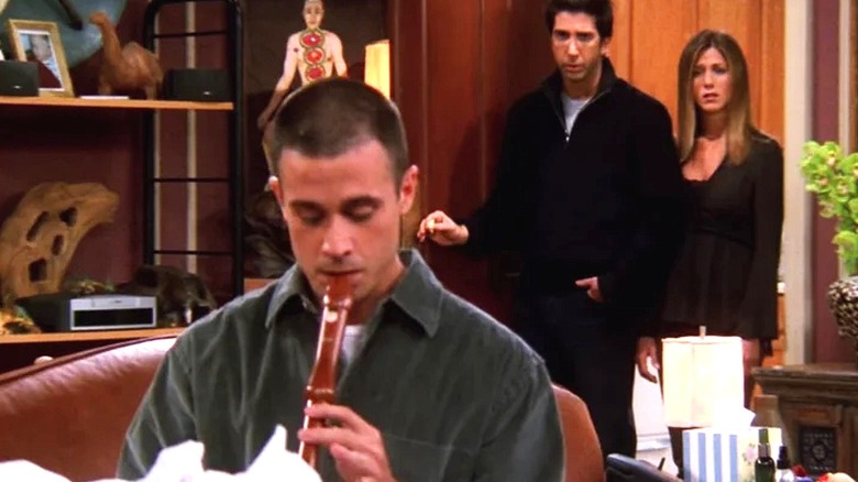 Sandy playing the flute as Ross and Rachel watch in an episode of Friends