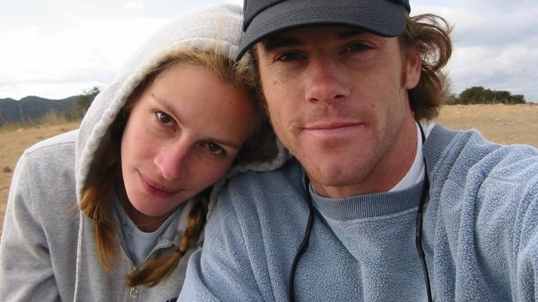 Julia Roberts leans on Danny Moder while sitting in a field