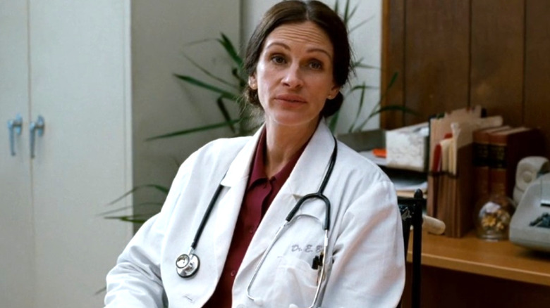 Dr. Emma Brookner in her lab coat sits in her office and looks toward the left