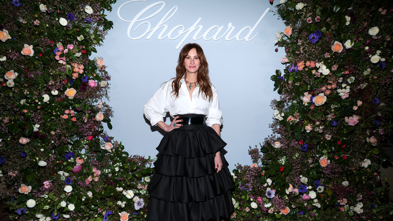 Julia Roberts stands in front of a floral background while attending the Chopard Collection launch in Los Angeles March 2024