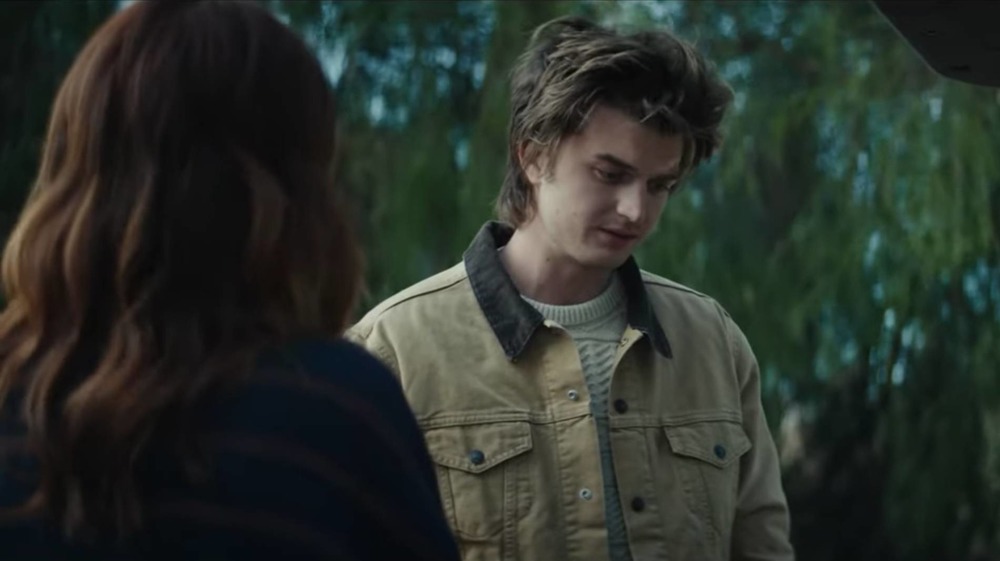 Joe Keery looks into a trunk