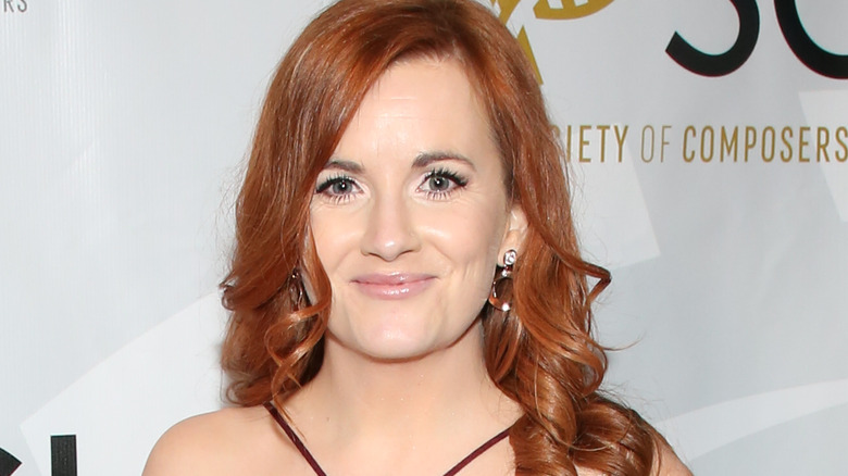 Composer Amie Doherty smiles in front of a white background