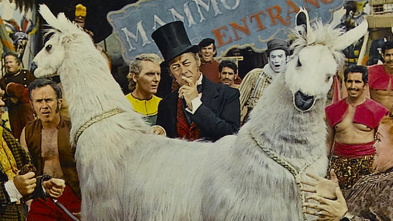 Rex Harrison stands with a creature