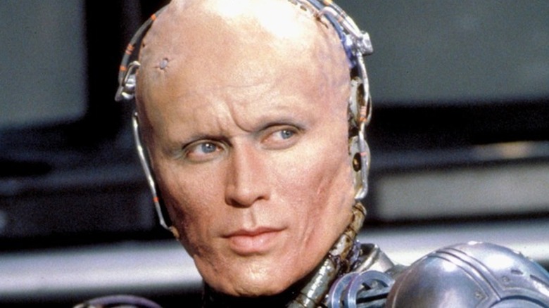 RoboCop without his mask looks over shoulder