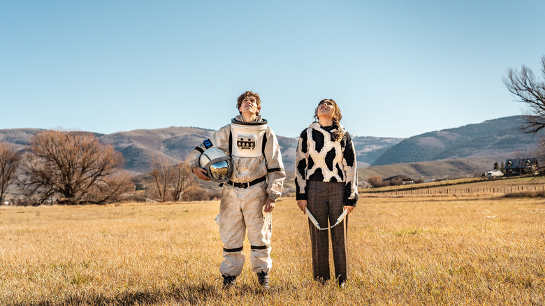 Emma Tremblay and Jacob Buster standing in field looking at sky