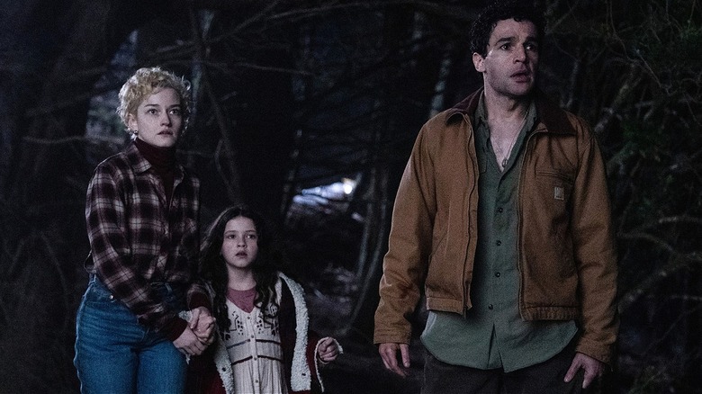 Charlotte, Ginger, and Blake in the dark woods in 