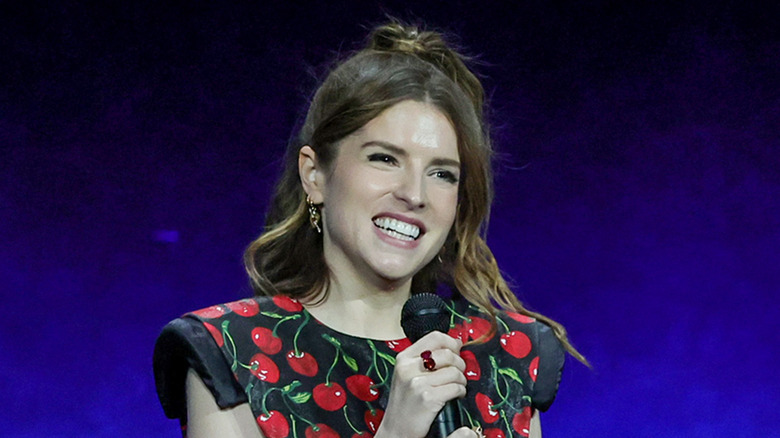 Anna Kendrick smiling holding microphone