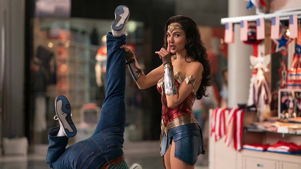 Diana Prince as Wonder Woman holding a man by his leg