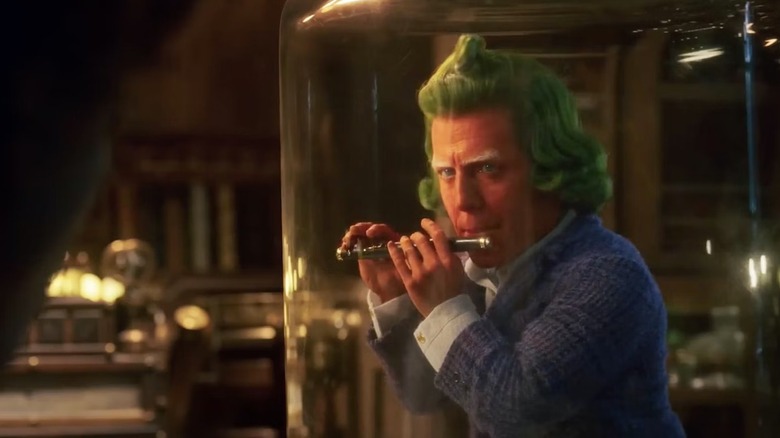 Lofty plays a flute inside a glass dome in "Wonka" (2023)