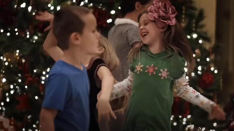 Kids dancing by Christmas tree