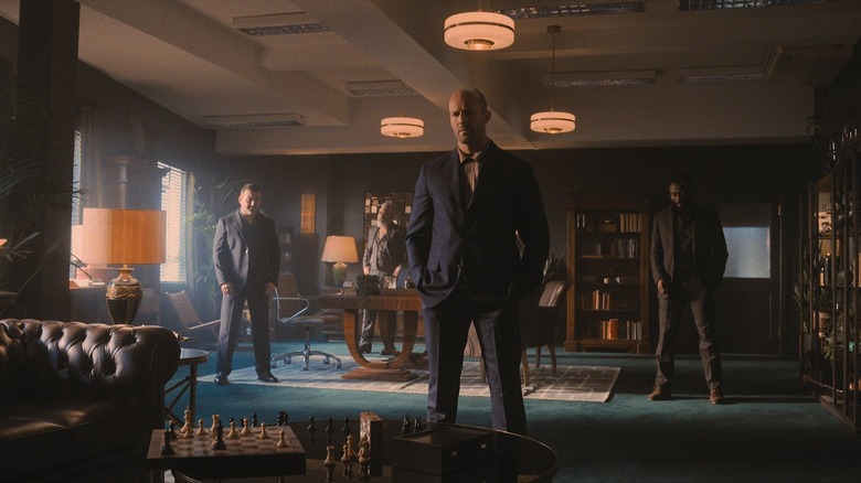 Jason Statham standing over chess game