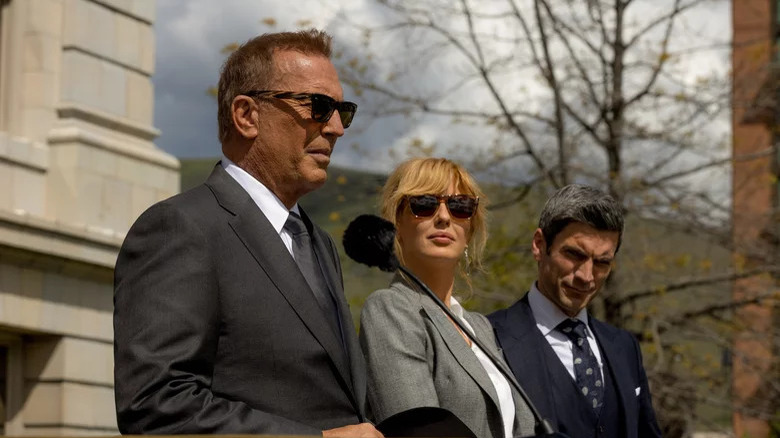 Kevin Costner, Kelly Reilly, and Wes Bentley standing outside in Yellowstone