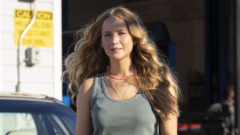 Maddie stands by a car