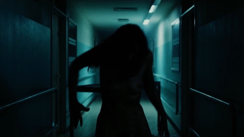 Woman's writhing silhouette in a dark hallway