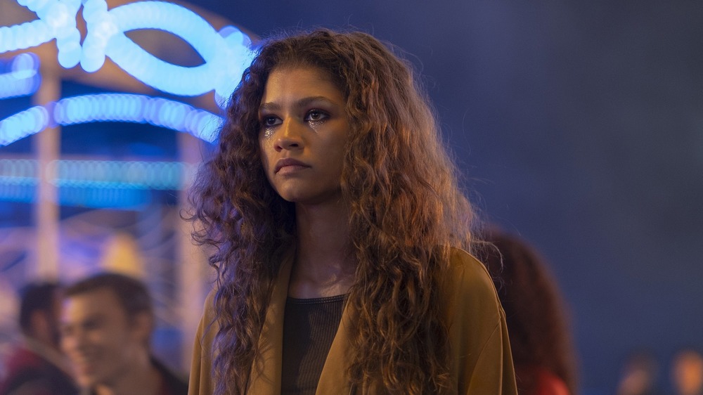 Zendaya stands in front of bright lights