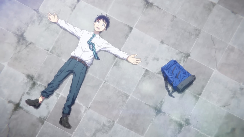 Akira Tendo lying on gorund nest to blue backpack